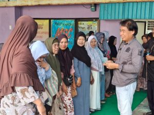 Dirham Zain saat memberikan santunan kepada janda tua usai kegiatan sosialisasi perda
